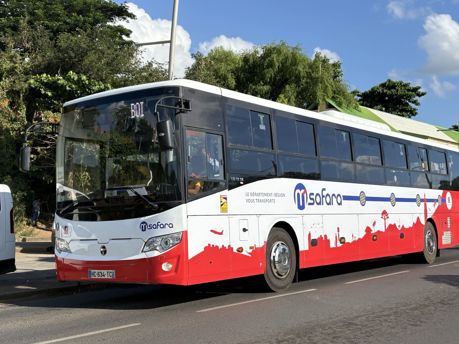 Un bus du réseau M'Safara du Département de Mayotte, à l'arrêt en bord de route.